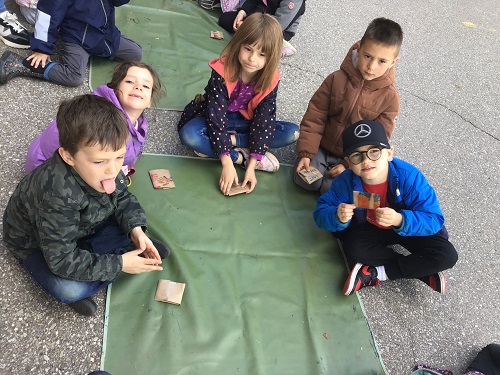 Children outside creating a craft for Mother's Day