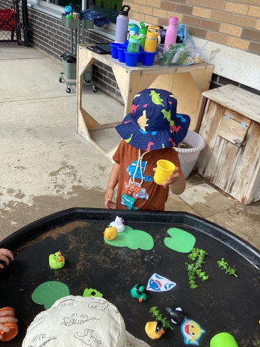 Children playing in the tuff tray with water