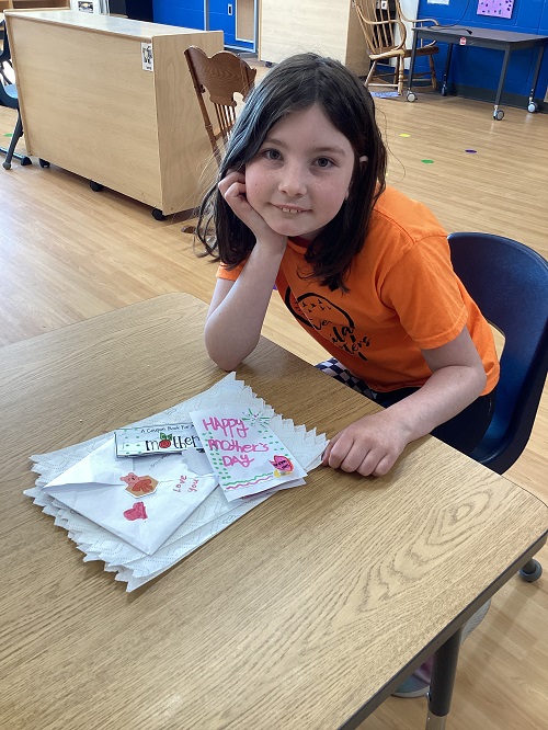 A school age child working on their mothers day creation