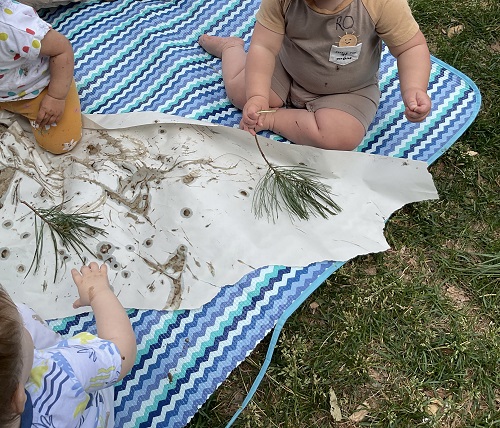 child using a branch as a brush
