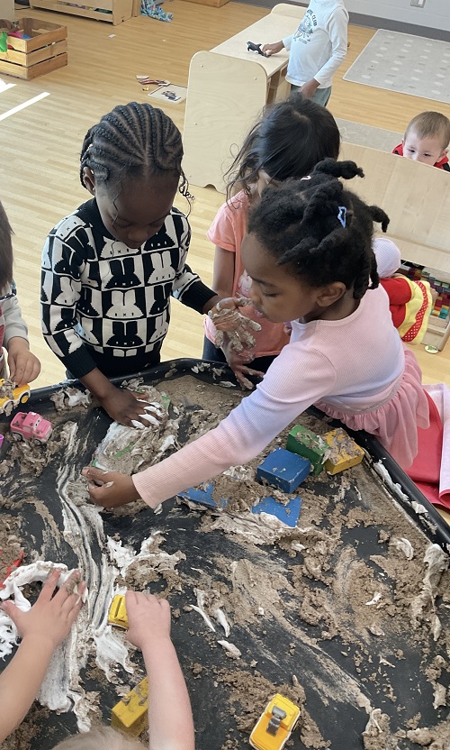 children at the tuff tray with cars