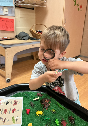 Child looking through magnifying glass