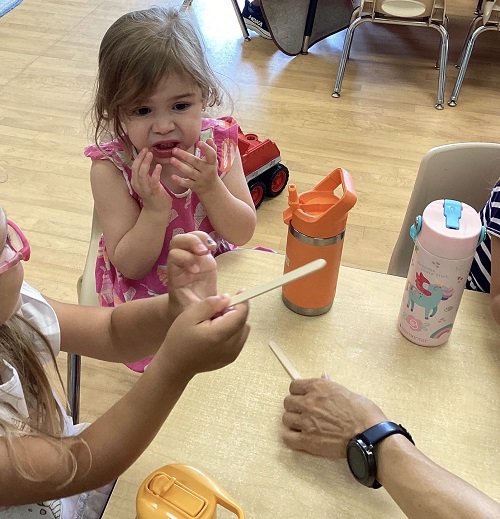 child tasting a sour lemon