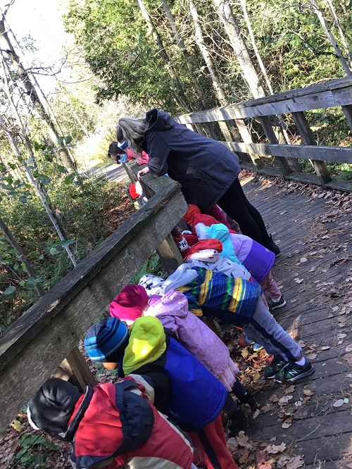 Preschool group looking through the bridge to see what is below